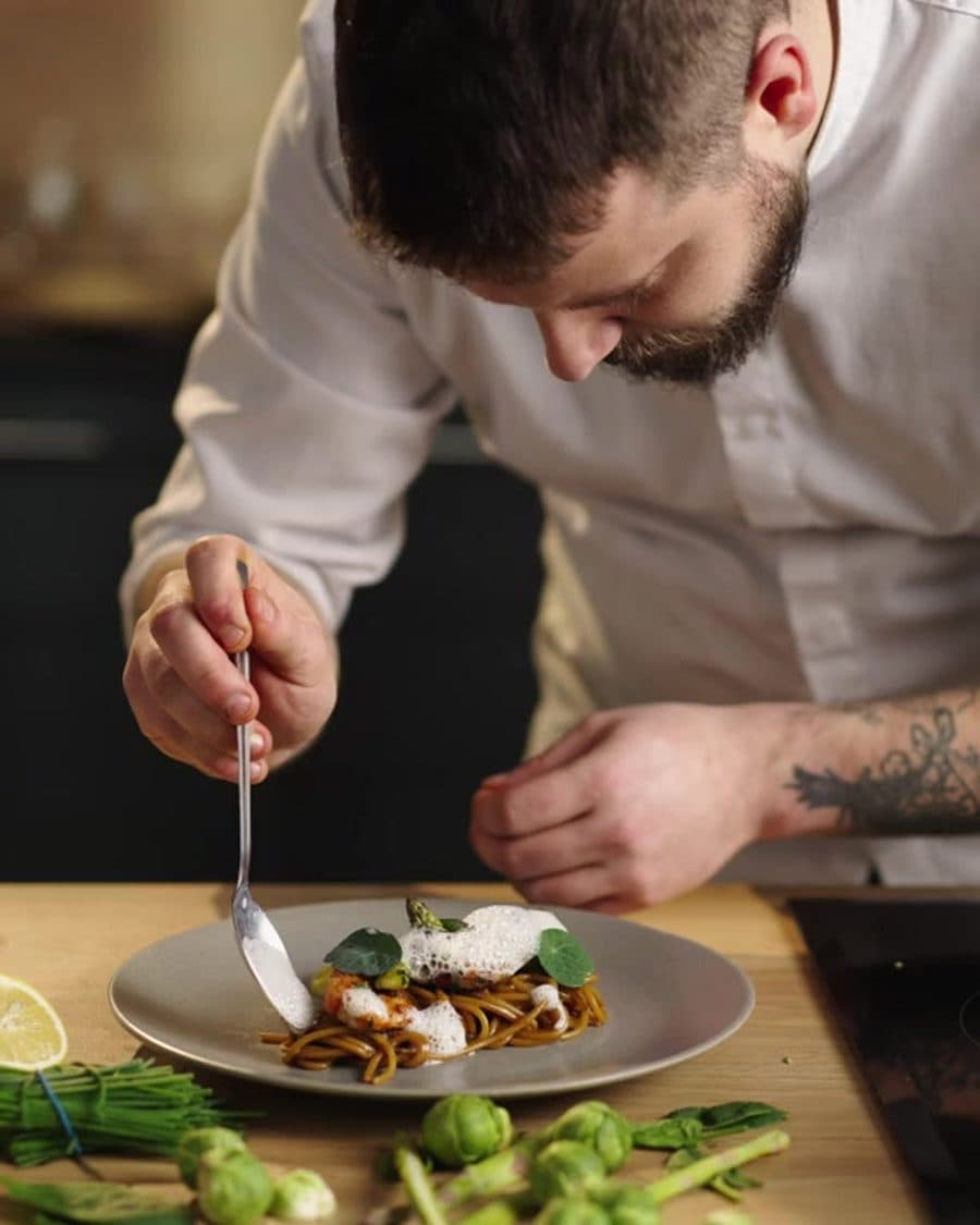 A chef plating a donburi by hand in the Don Rice Bar kitchen